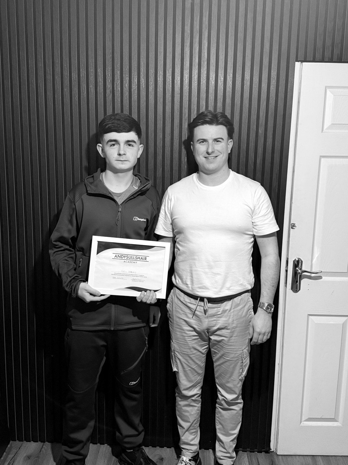A graduate holding his certificate beside Andy at the Cork City shop