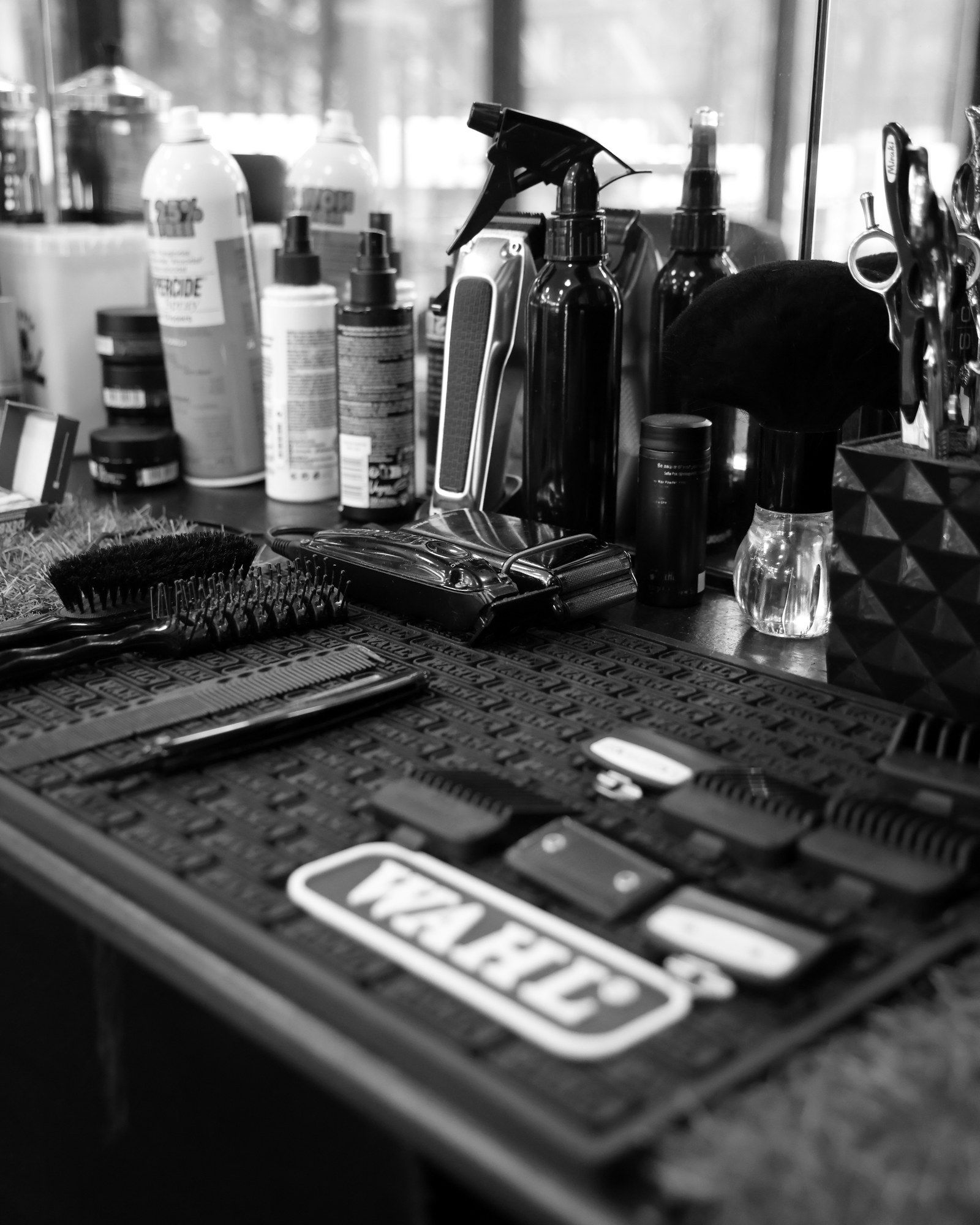 A professional barber kit laid out on the station: clippers, trimmers, scissors and combs